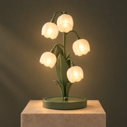 Muguet lily of the valley lamp switched on, five bell shades glowing warm
