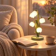 Muguet lamp lit beside a reading chair at sunset