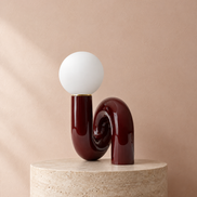 Swirl globe table lamp in dark red with a frosted glass globe, switched off