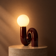 Swirl globe table lamp in dark red switched on, globe glowing warm