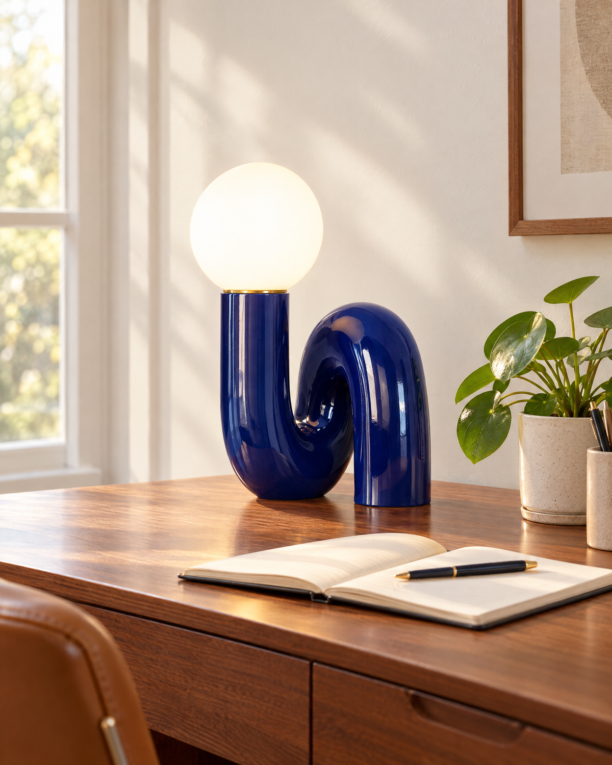 Blue swirl globe table lamp on a walnut desk in a home office