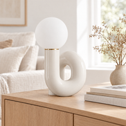 White swirl globe table lamp on an oak sideboard in a bright living room