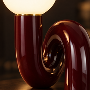 Close-up of the glowing frosted glass globe and glossy dark red curve