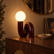 Dark red swirl globe lamp glowing on an entryway console at night